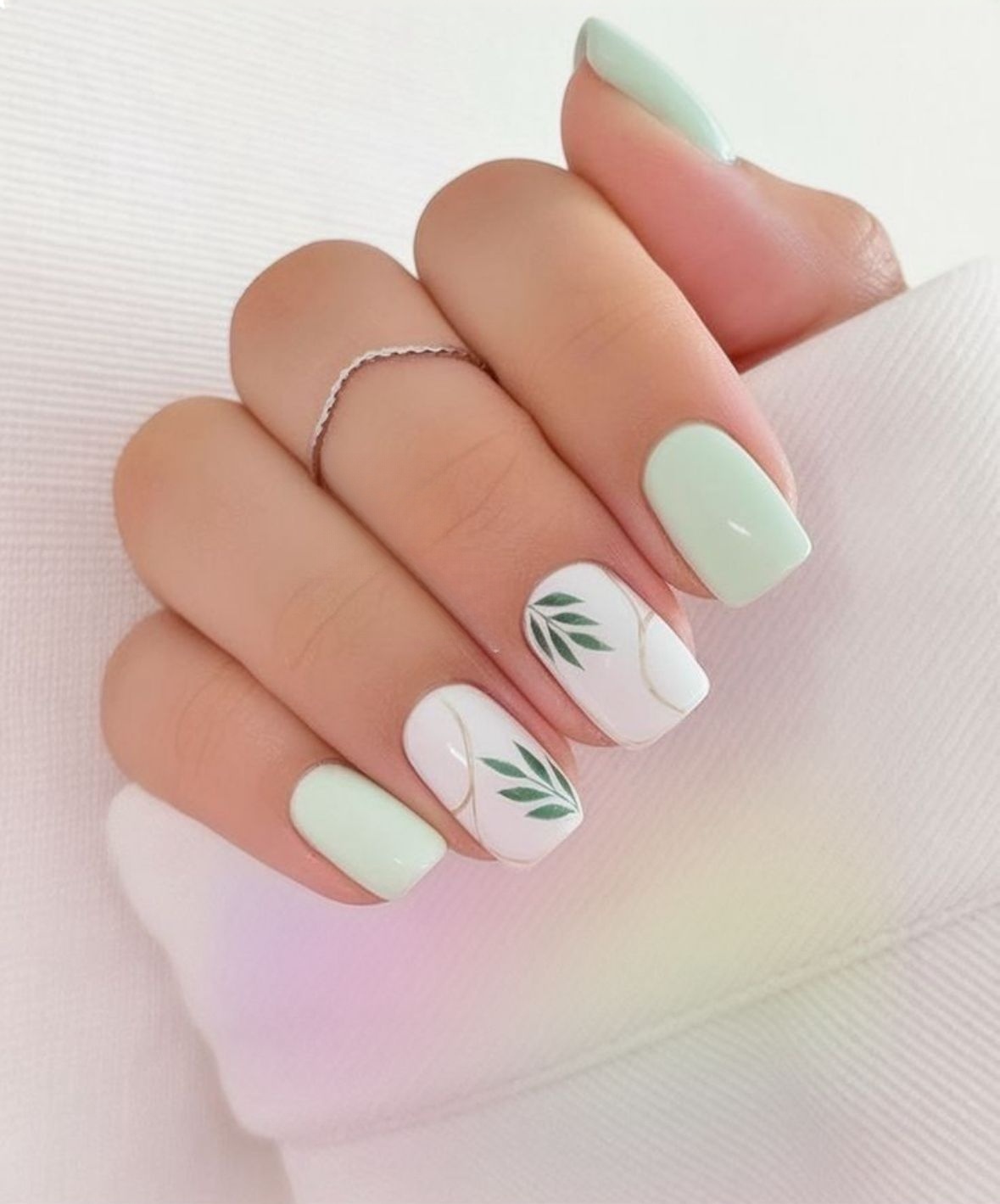 Mint green and white nail art with leaf design